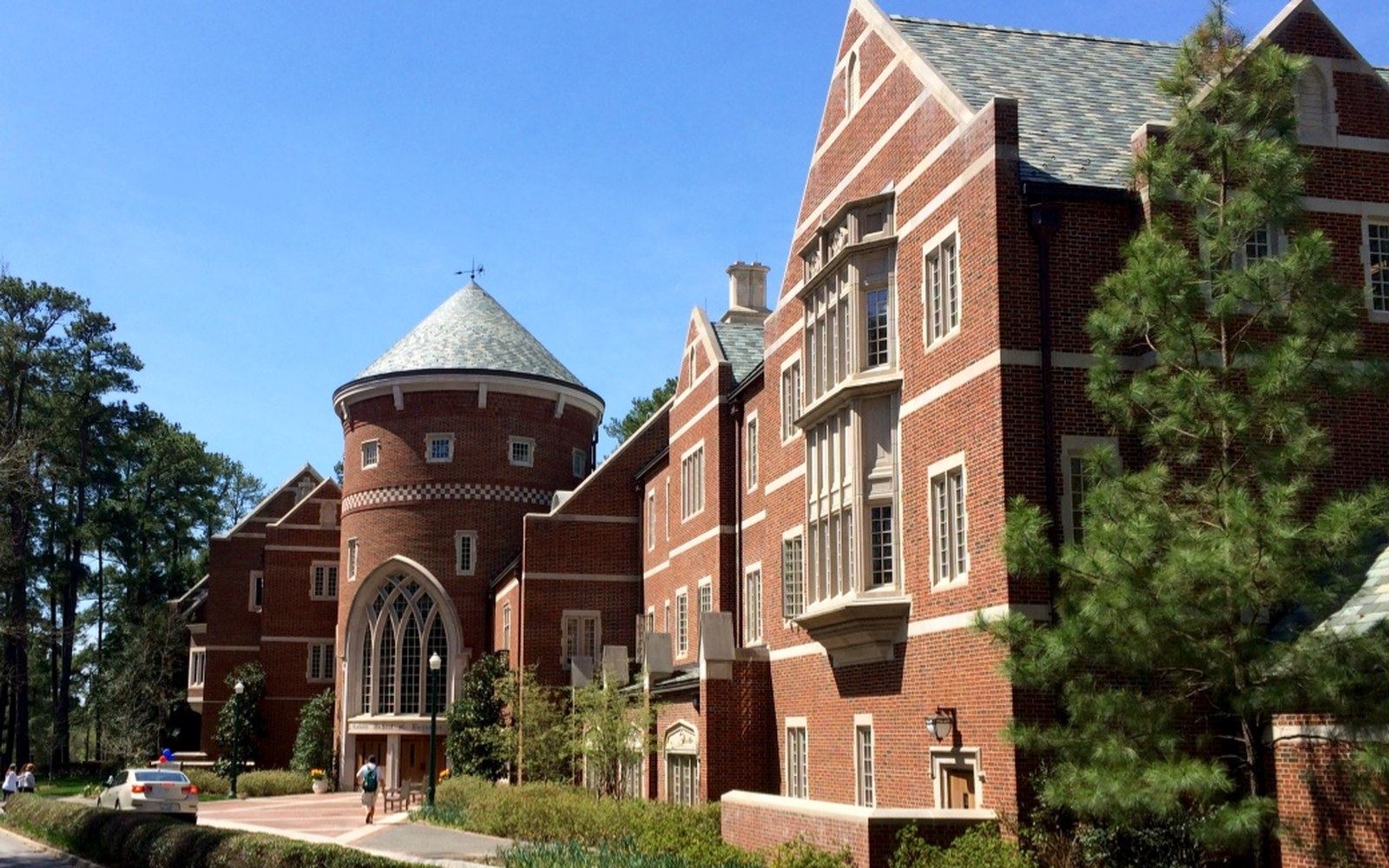University of Richmond collegiate Gothic exterior, late afternoon, adult crew member in foreground